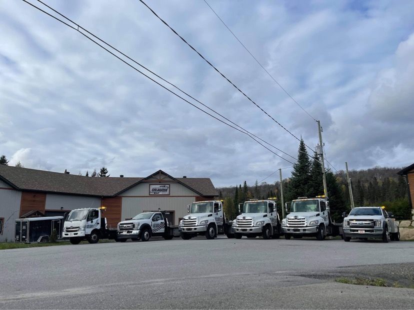 Une rangée de dépanneuses garées devant un bâtiment