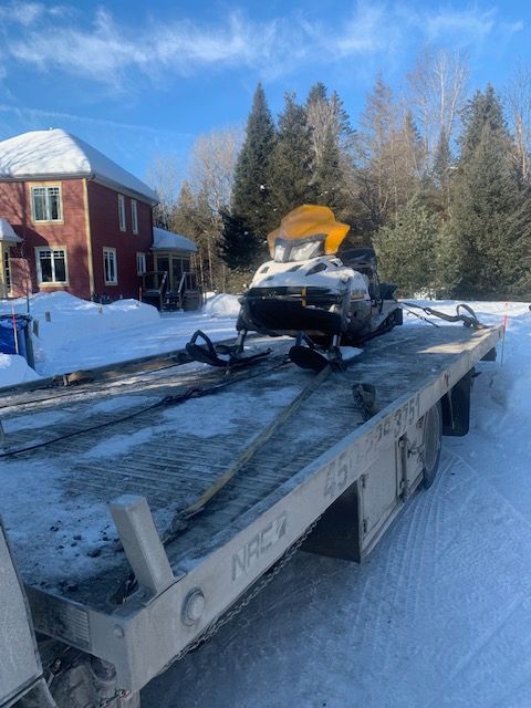 Une motoneige est à l'arrière d'une dépanneuse.