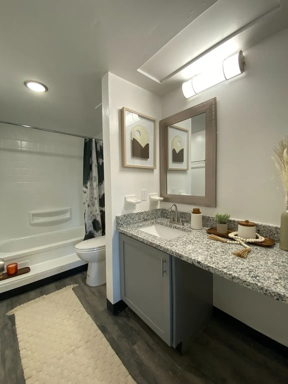 Modern bathroom with a sink, mirror, and shower at Haven on the Lake in Maryland Heights, MO.