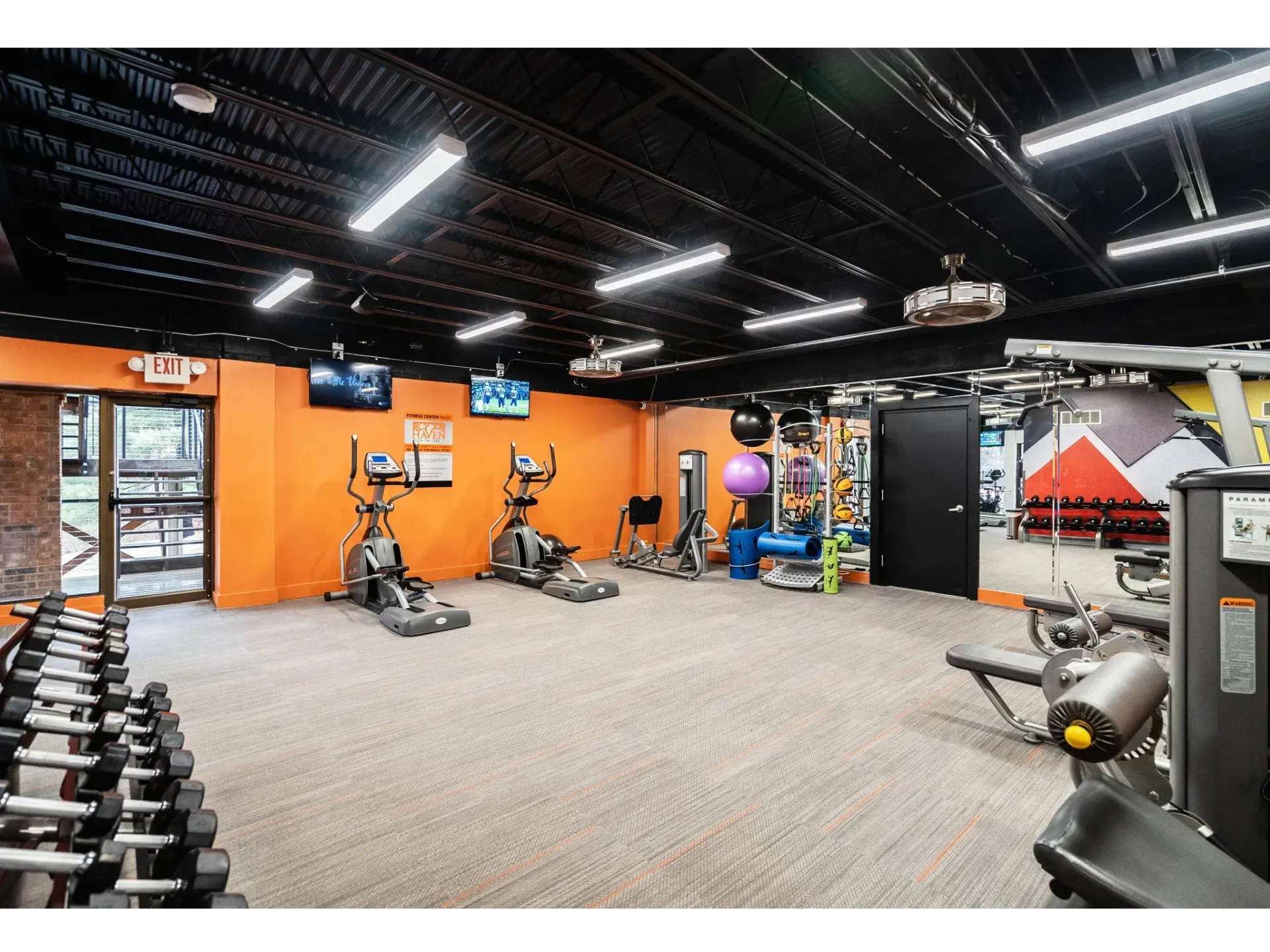 Interior view of a modern gym with exercise equipment and bright walls at Haven on the Lake in Maryland Heights, MO..