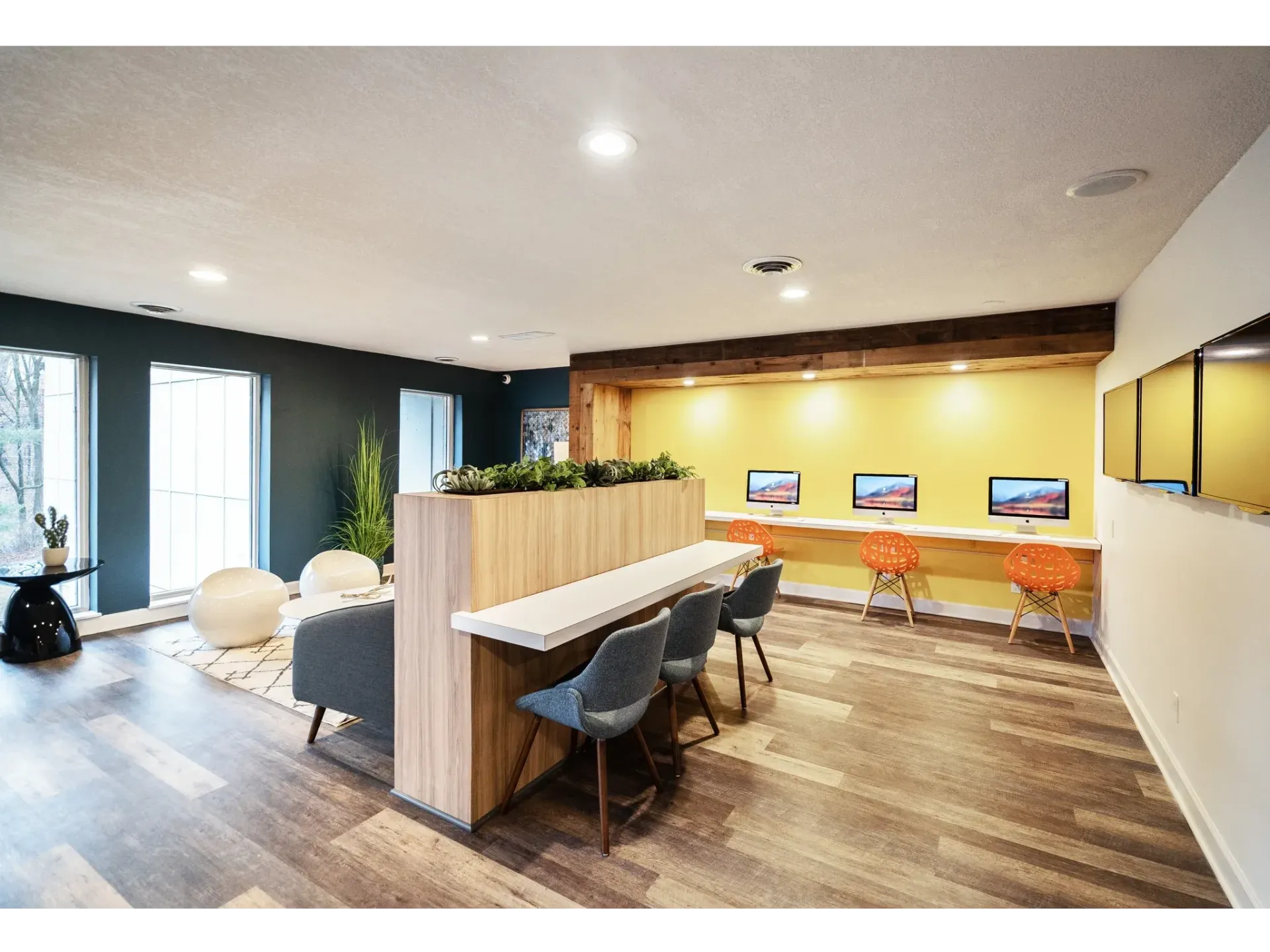 Community lounge with computer stations, seating, and plants.