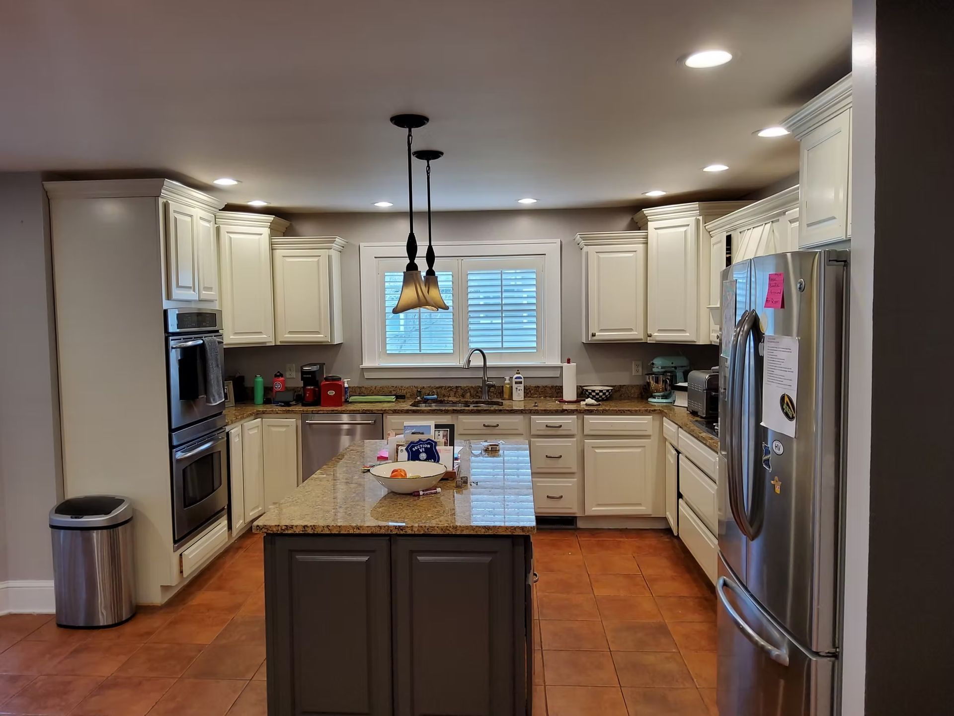 Kitchen with white cabinets, stainless steel appliances, and a gray island with granite countertop.