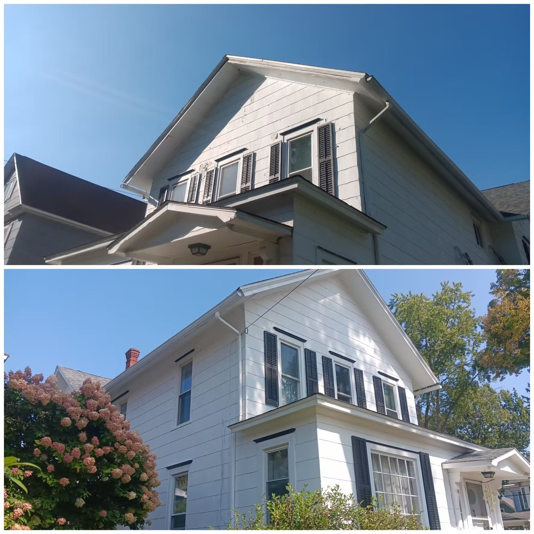Two-story white house with black shutters, angled view, blue sky, and foliage.