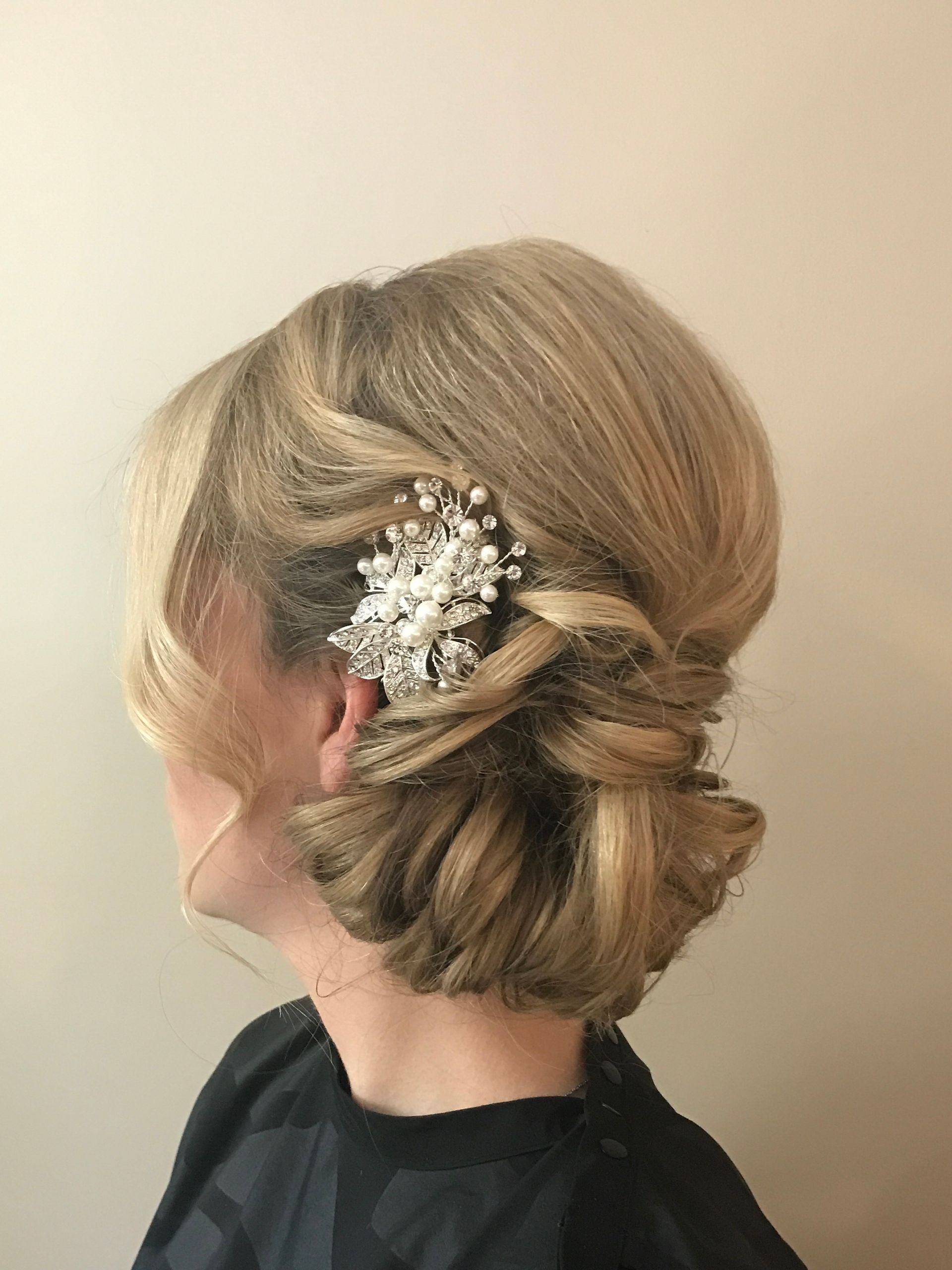 Blonde hair updo with braid and jeweled hair clip.