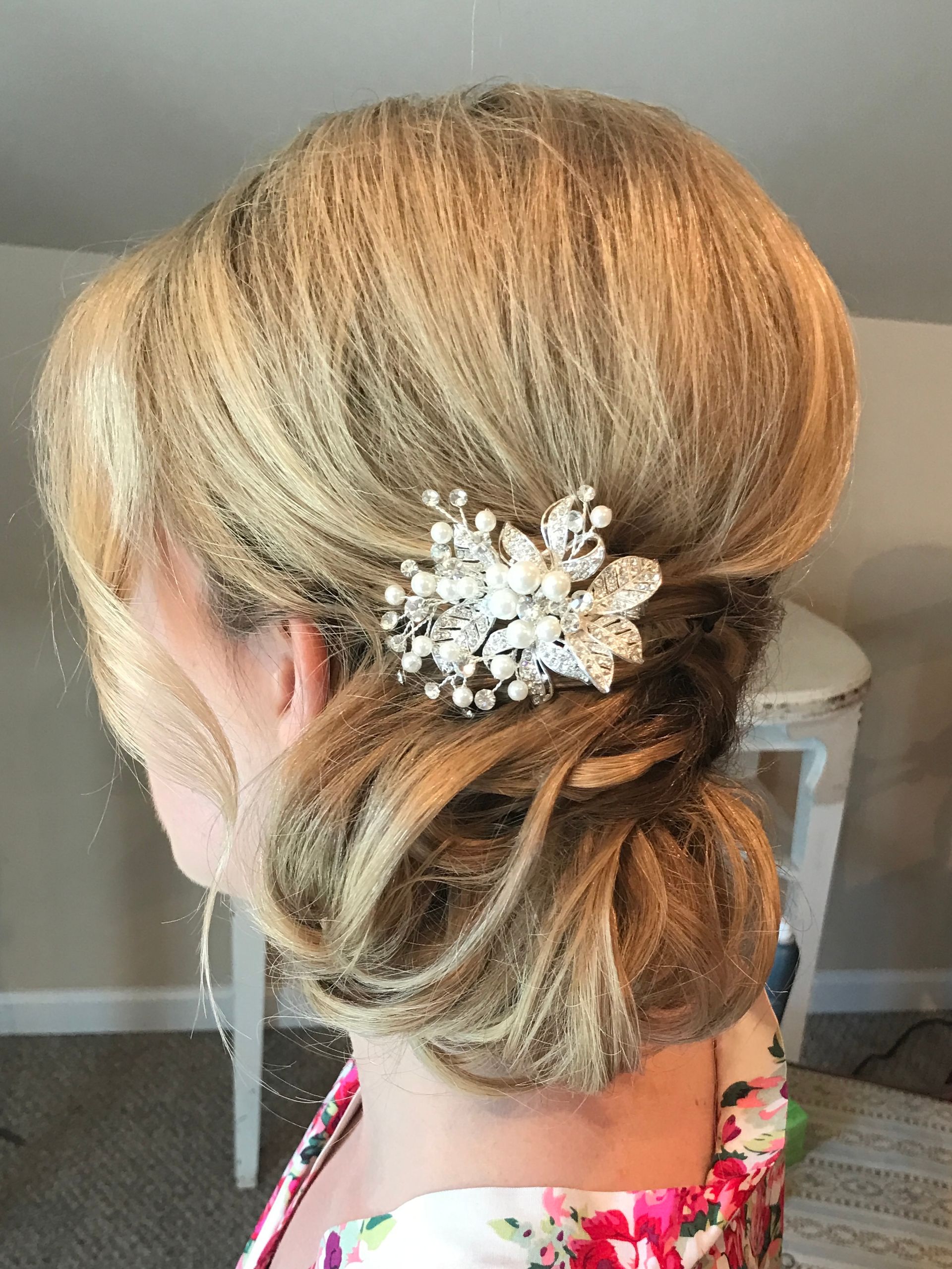 Blonde updo with a jeweled hair clip, viewed from the side.