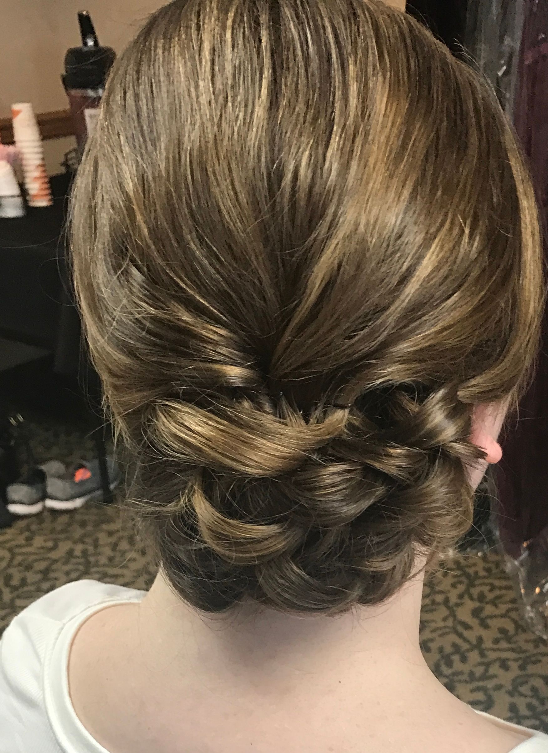 Woman with styled brown hair in a low twisted bun, viewed from the back.