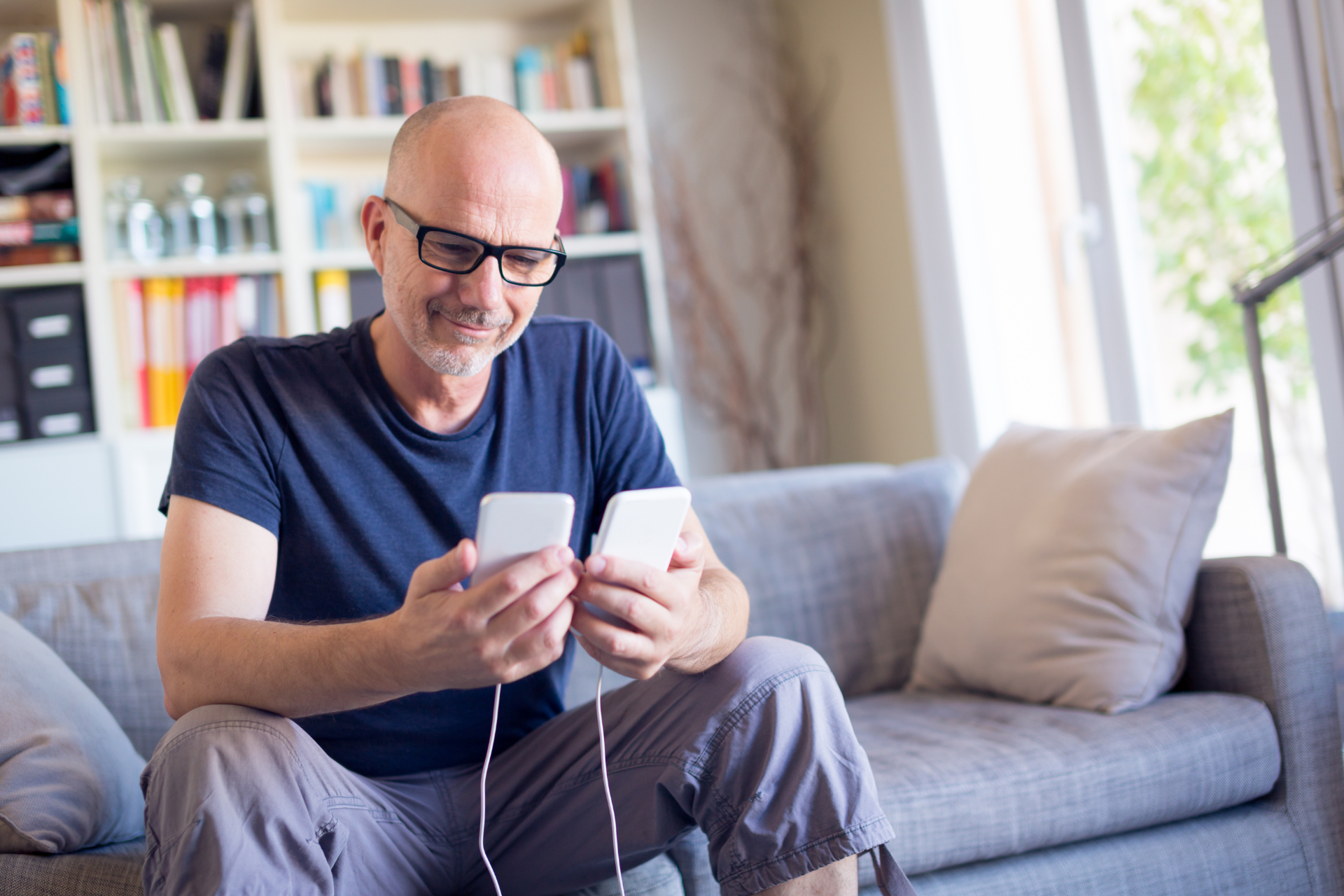 Man transferring data between his old and new smart phones