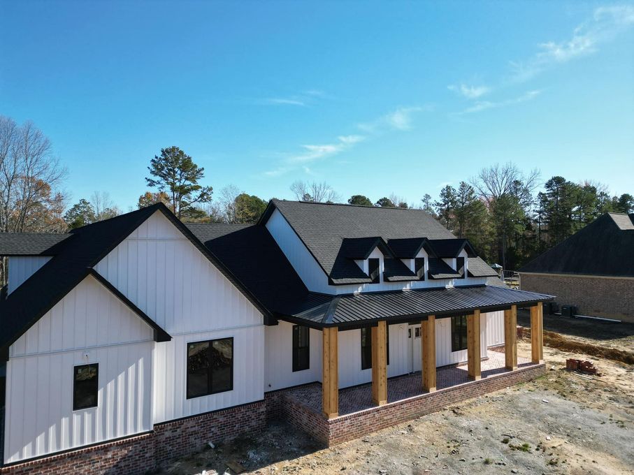 An aerial view of a house under construction with a black roof.