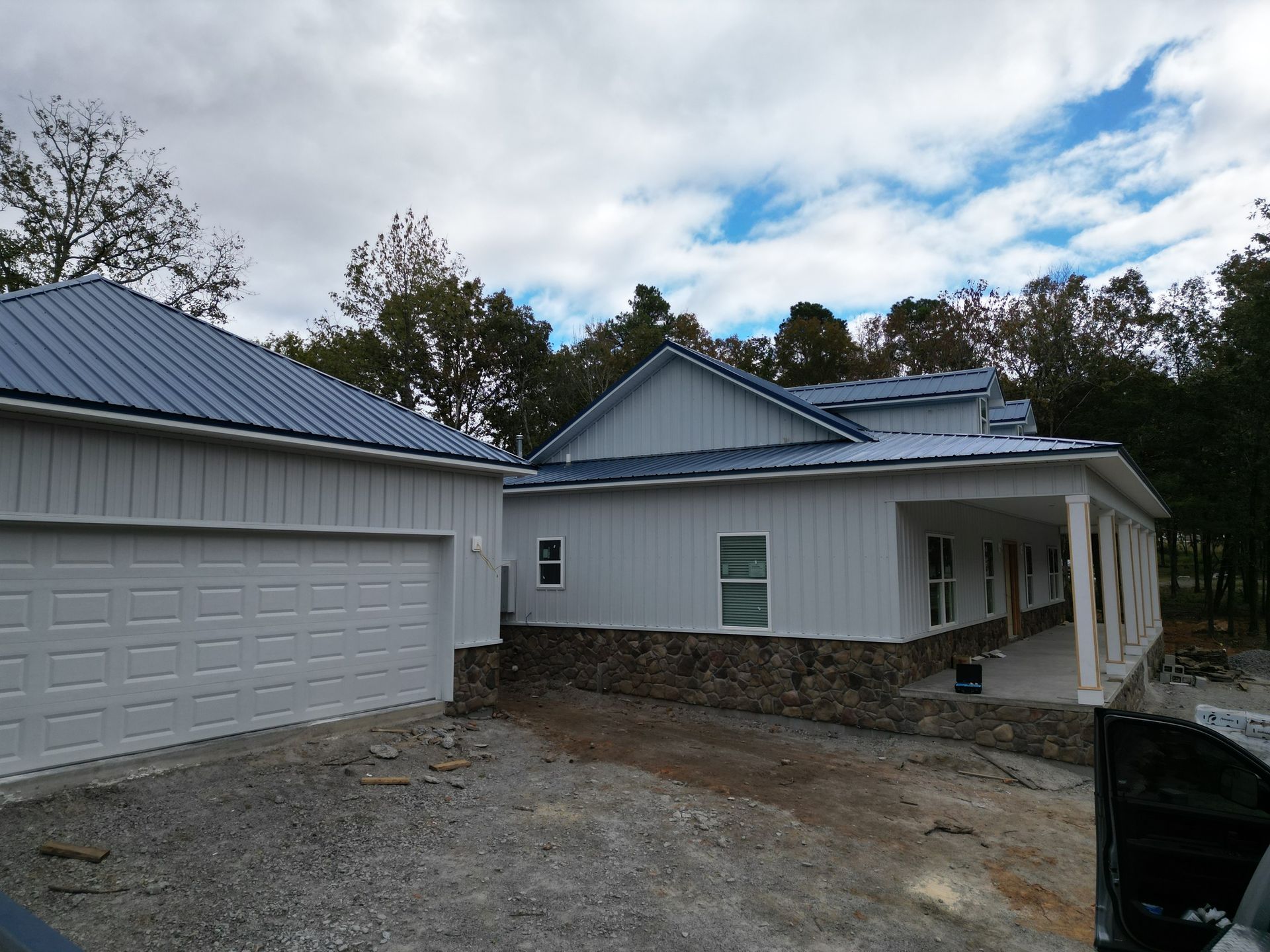 A white house with a blue roof is being built