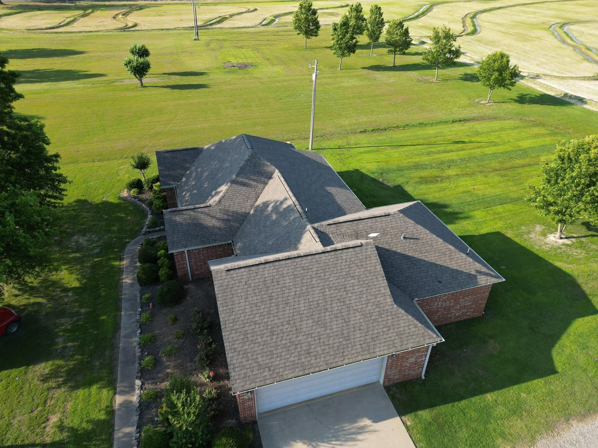 An aerial view of a house with a large lawn in front of it