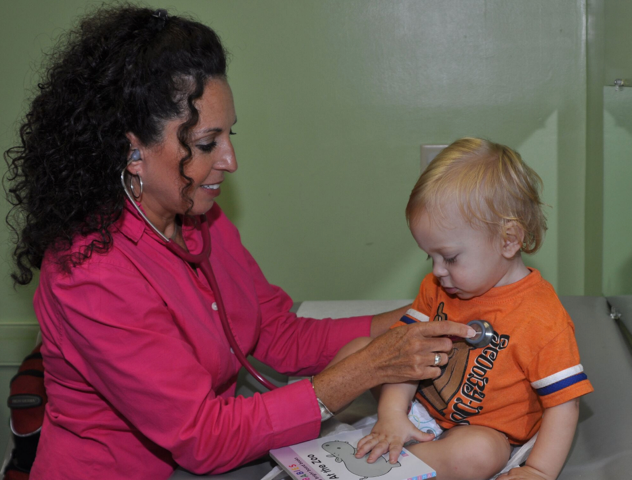 A female doctor is examining a baby with a stethoscope