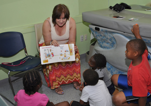 A woman is reading a book to a group of children