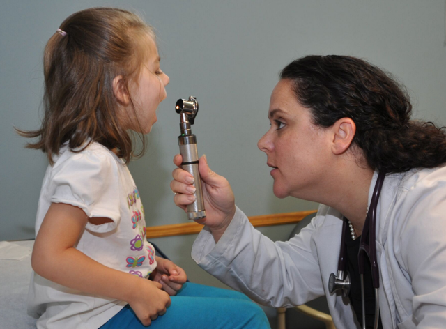A doctor examining a young girl