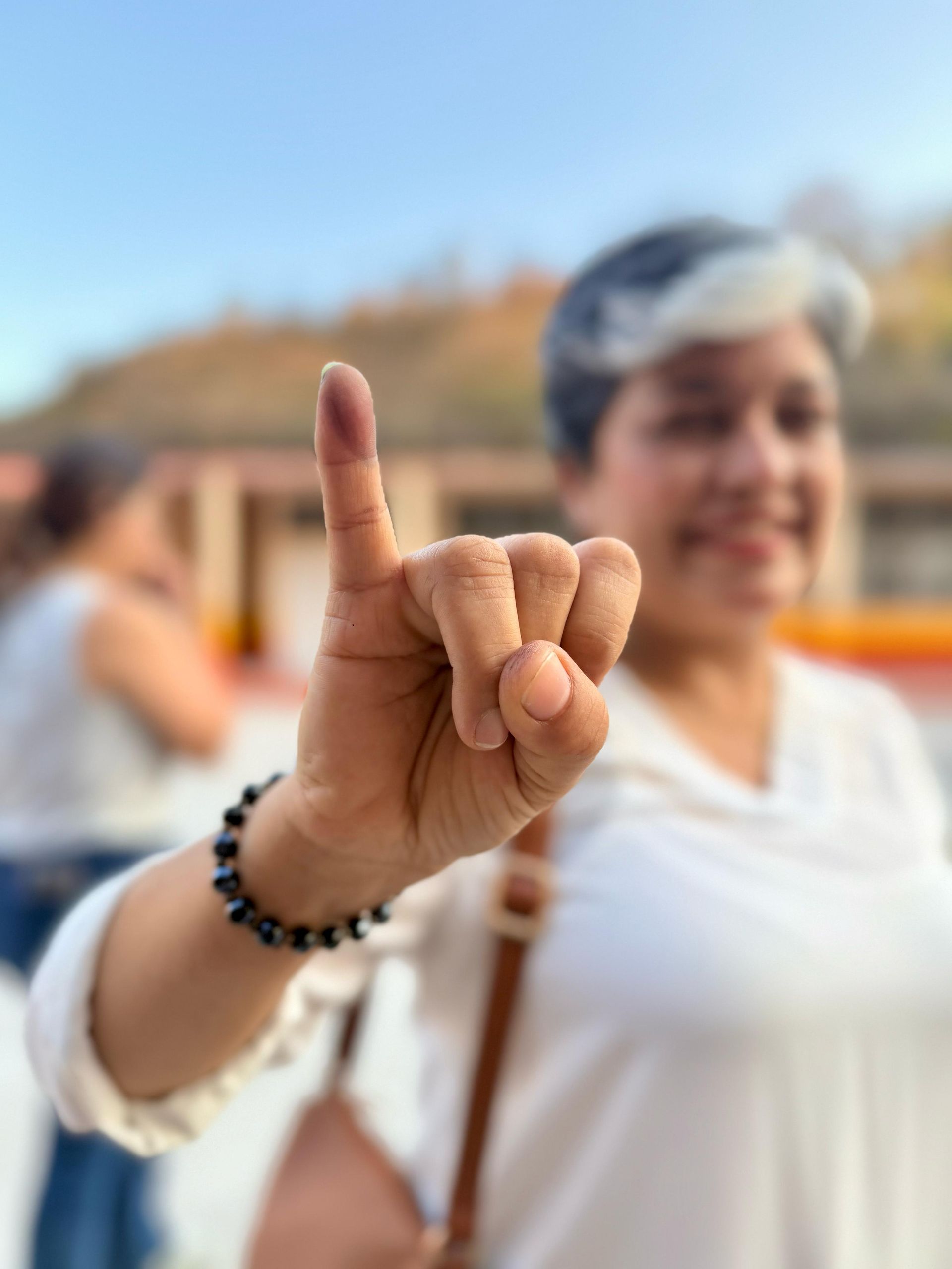 Young honduran woman proudly shows her ink-stained pinky, a mark Hondurans receive as a proof they have voted.