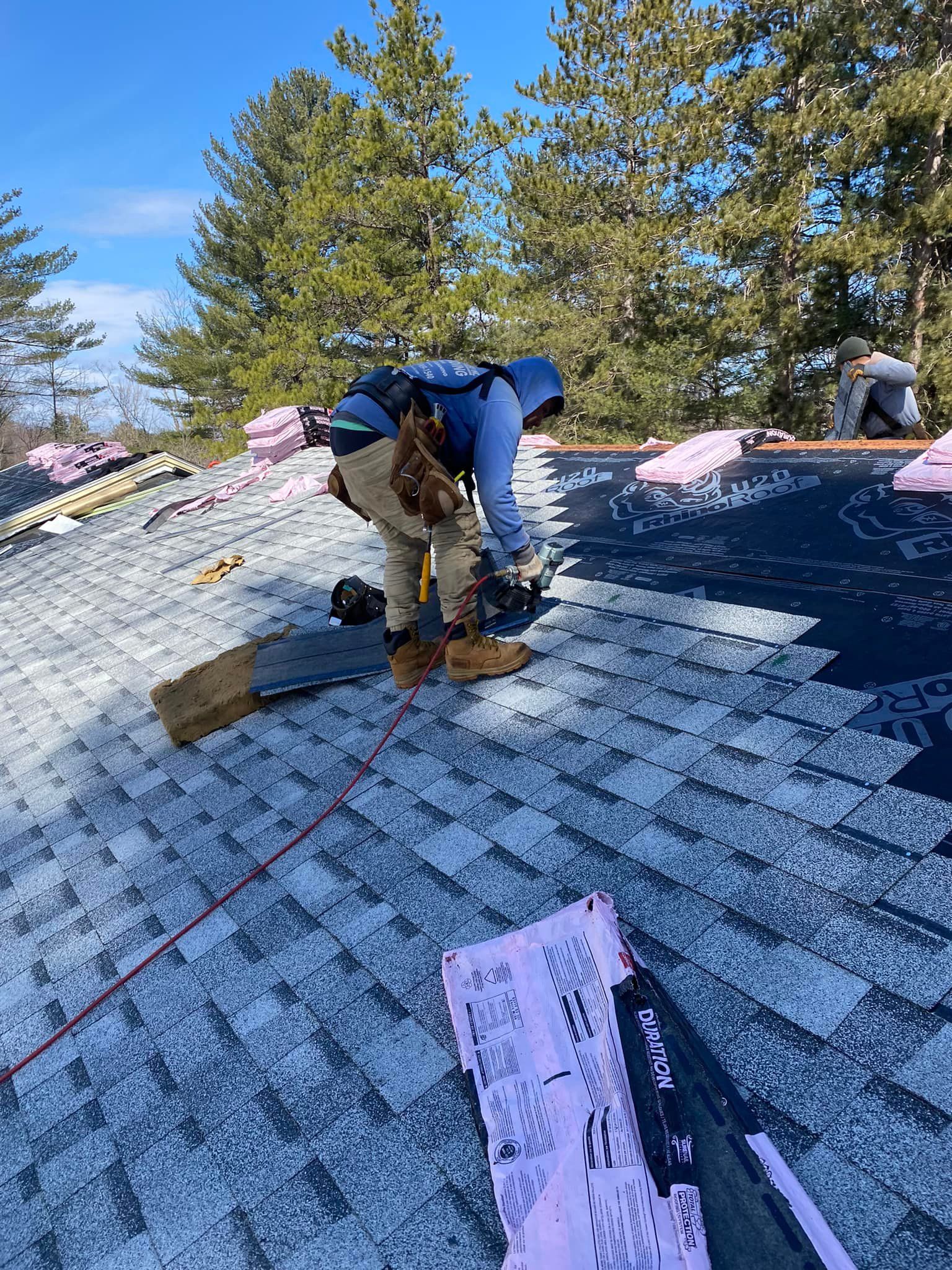 A man is working on the roof of a house.