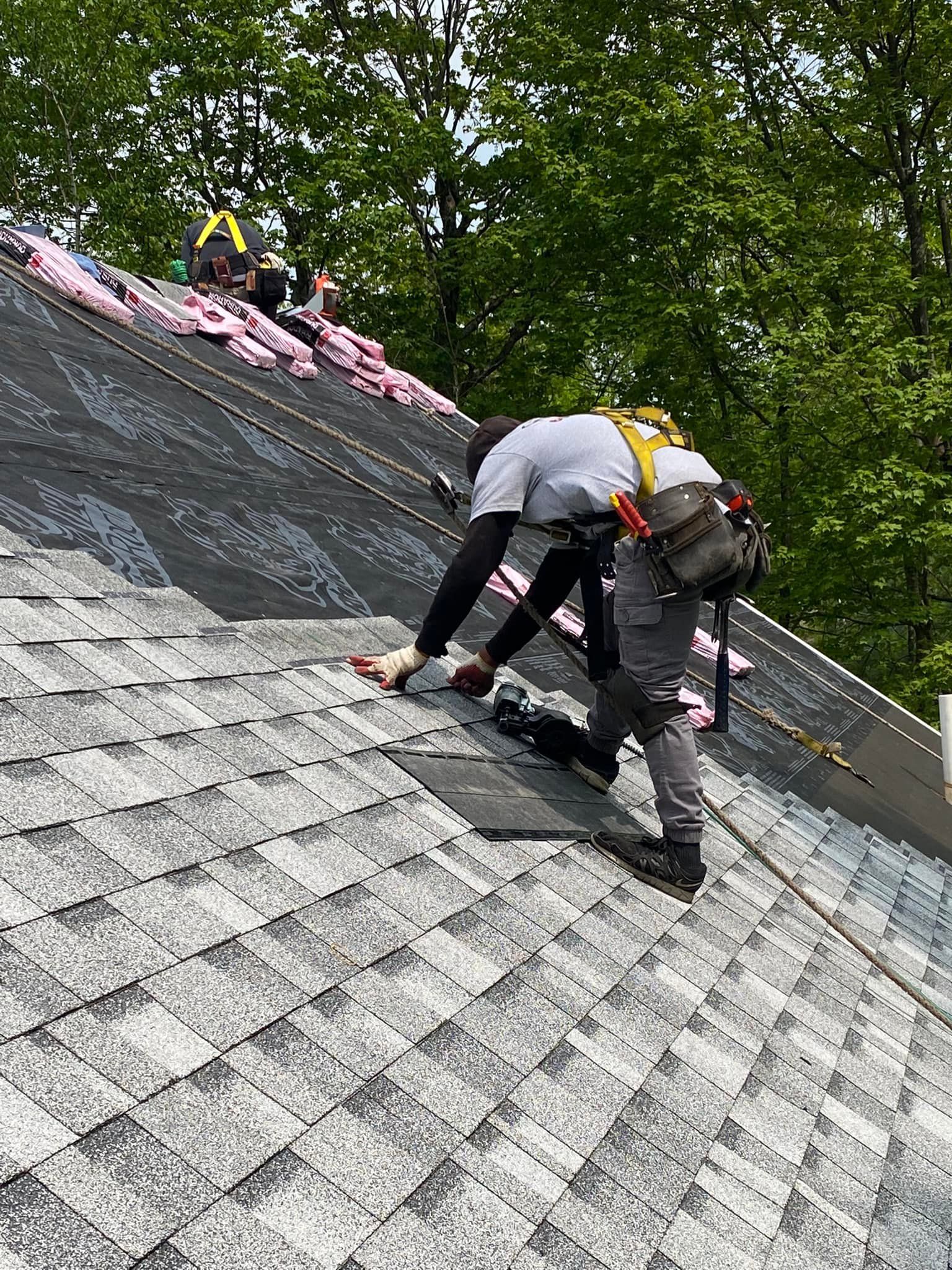 A man is working on the roof of a house.