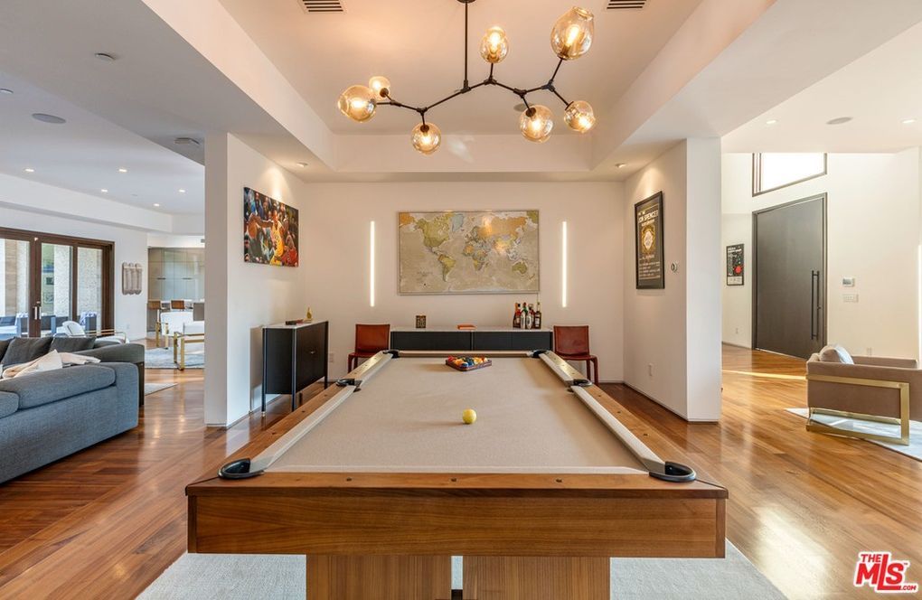 A pool table is in the middle of a living room.