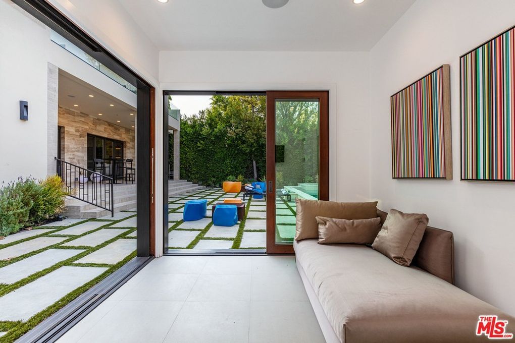 A living room with a couch and a sliding glass door leading to a patio.