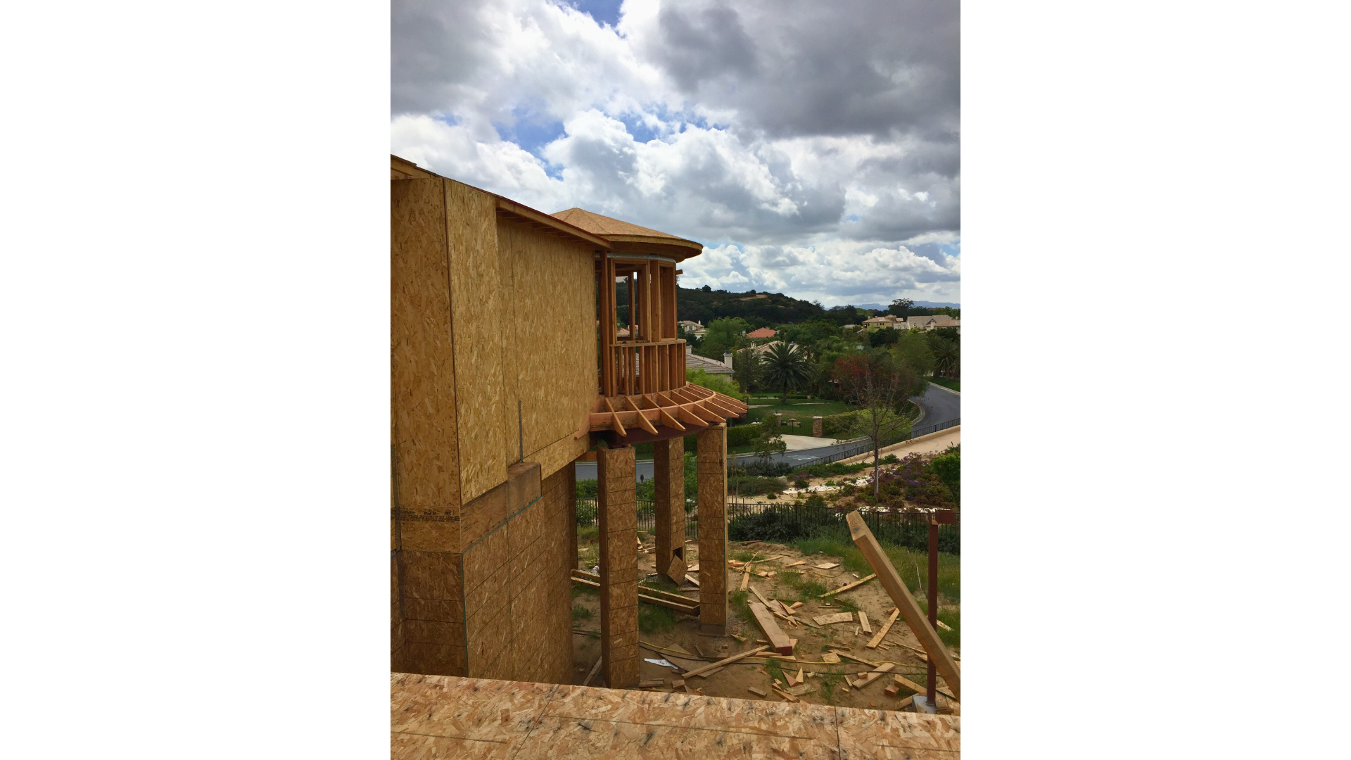A wooden structure is being built on top of a hill.