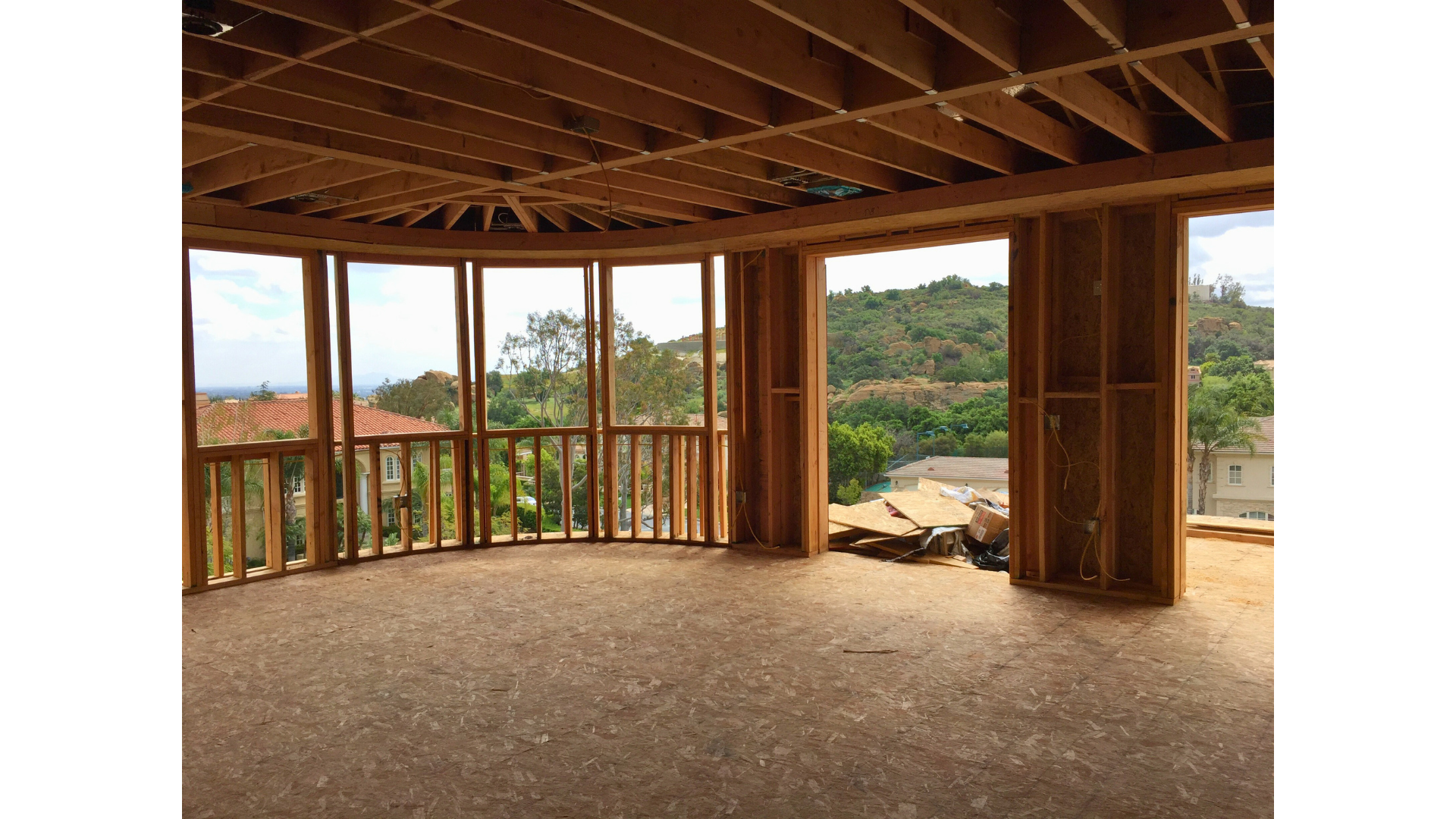 A room with a lot of windows and a balcony in a house under construction.