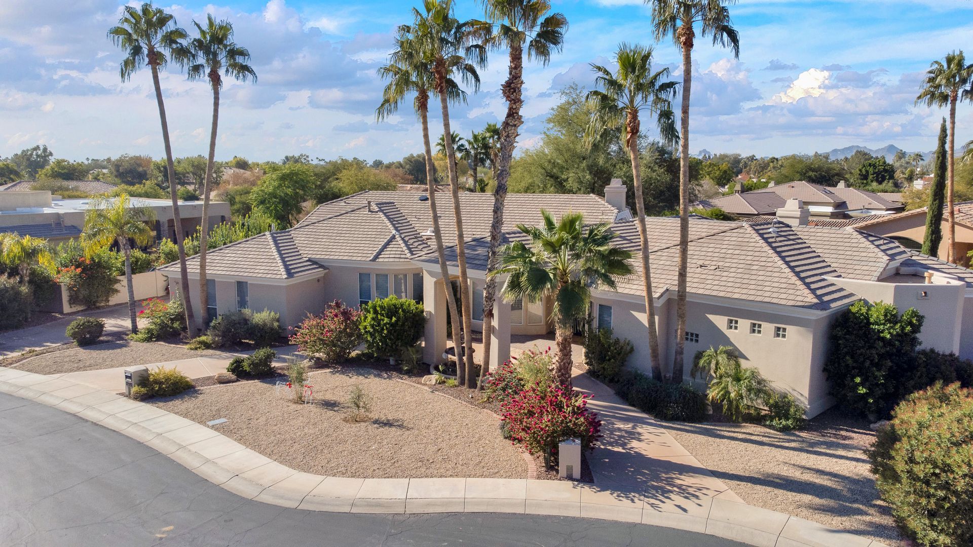 An aerial view of a house with palm trees in front of it