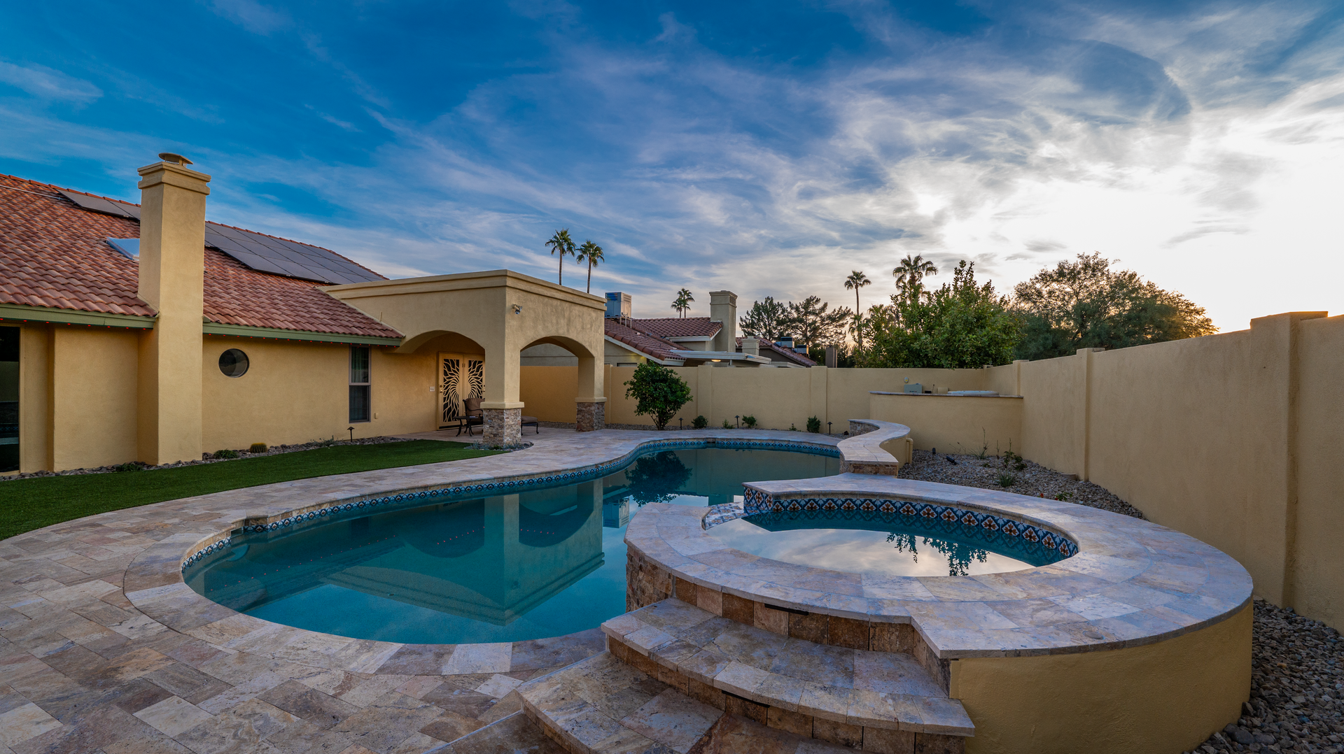 A large swimming pool with a hot tub in the backyard of a house in Cave Creek, Arizona