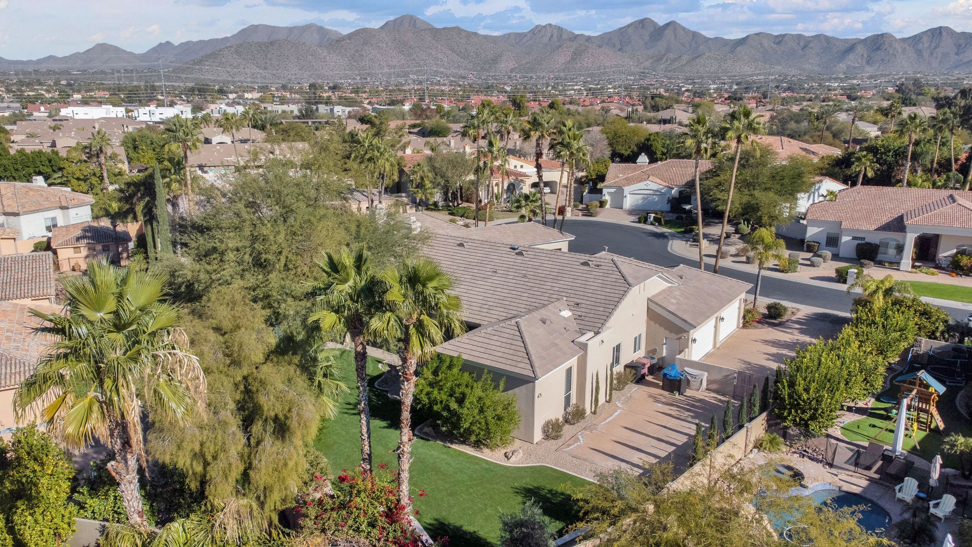 An aerial view of a residential area with mountains in the background.