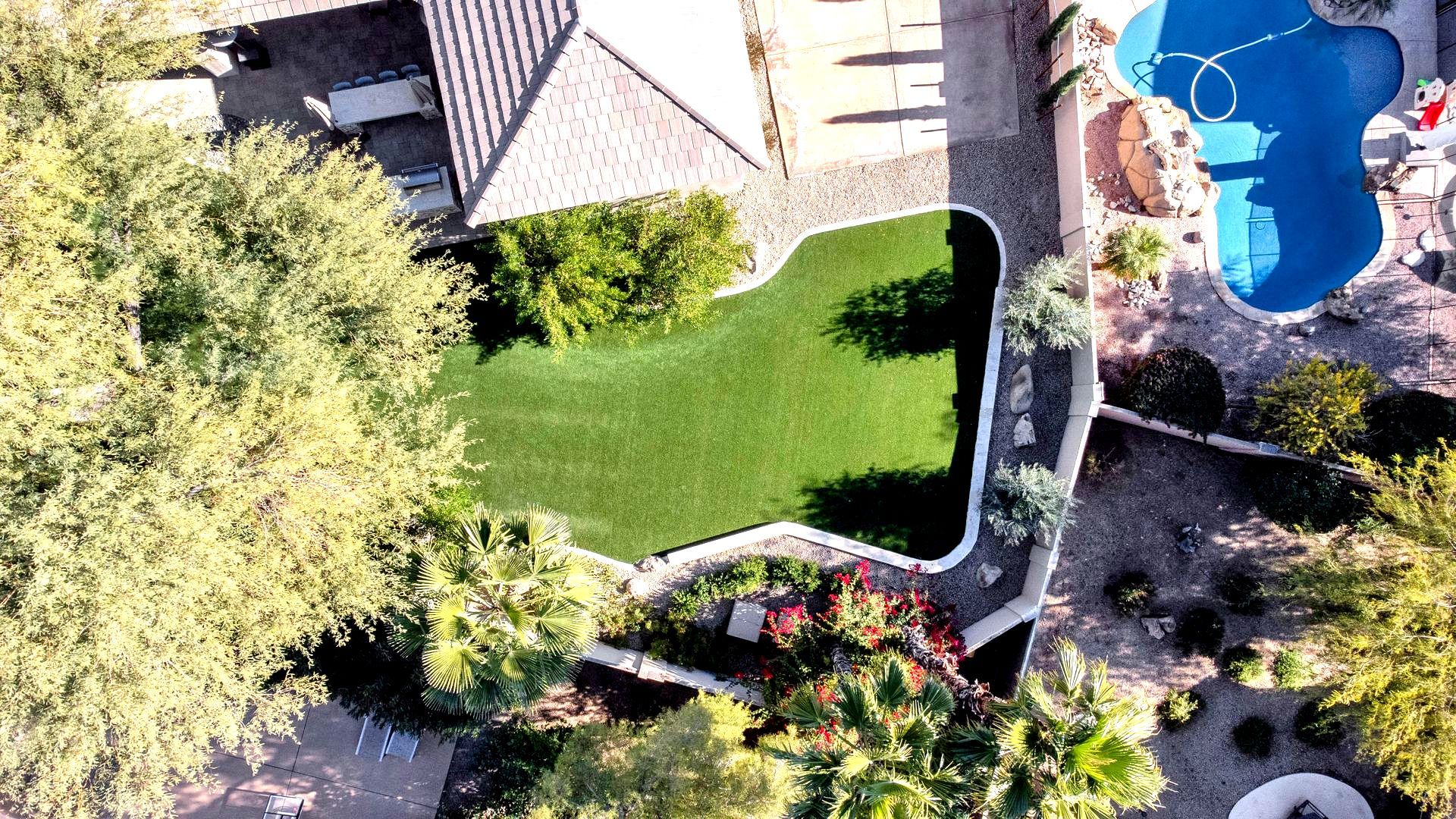 An aerial view of a backyard with a swimming pool and a house.