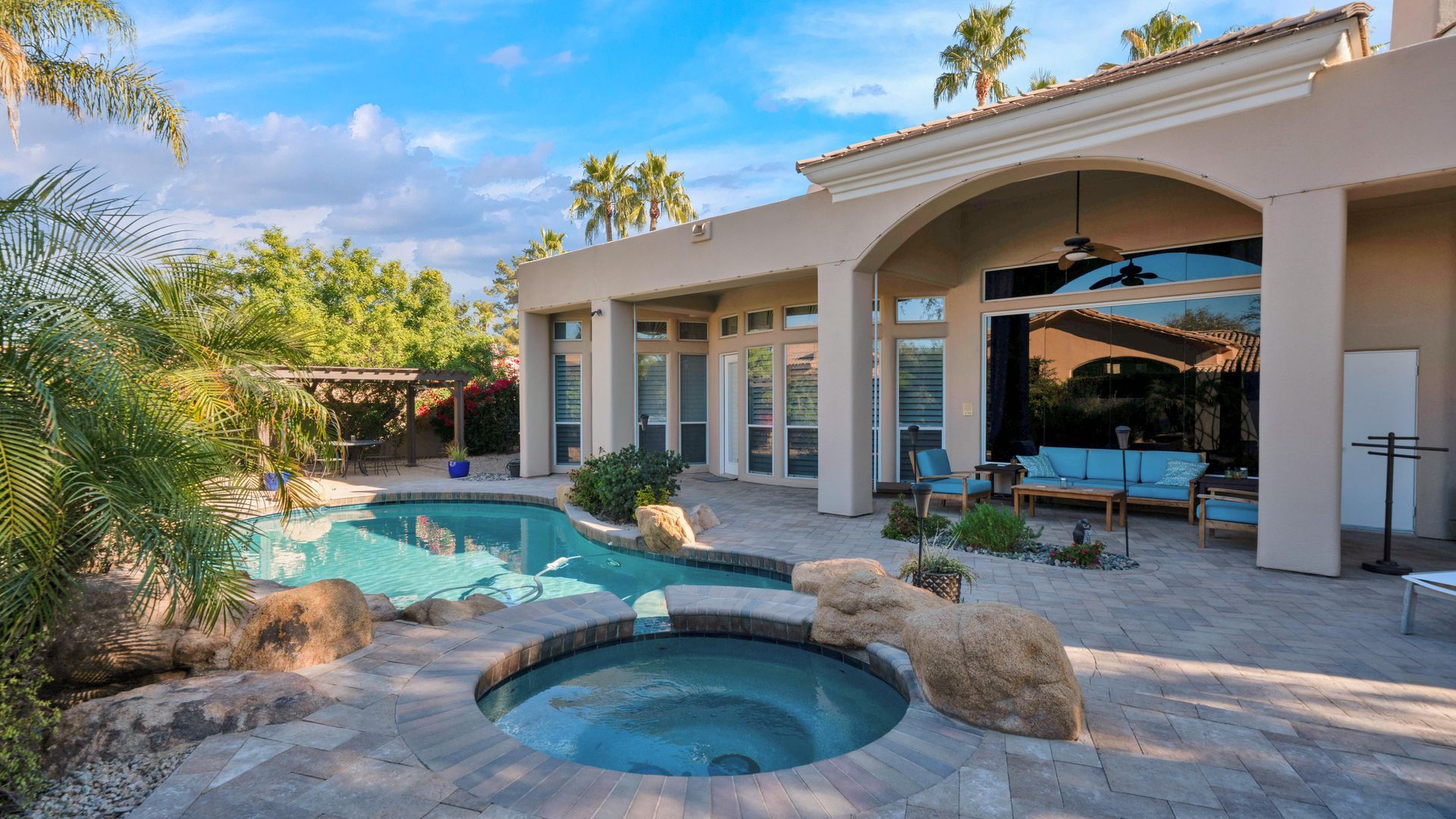 A large house with a swimming pool and a hot tub in the backyard.