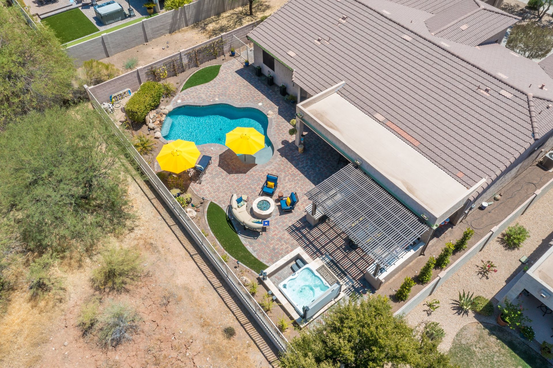 An aerial view of a house with a pool and umbrellas.