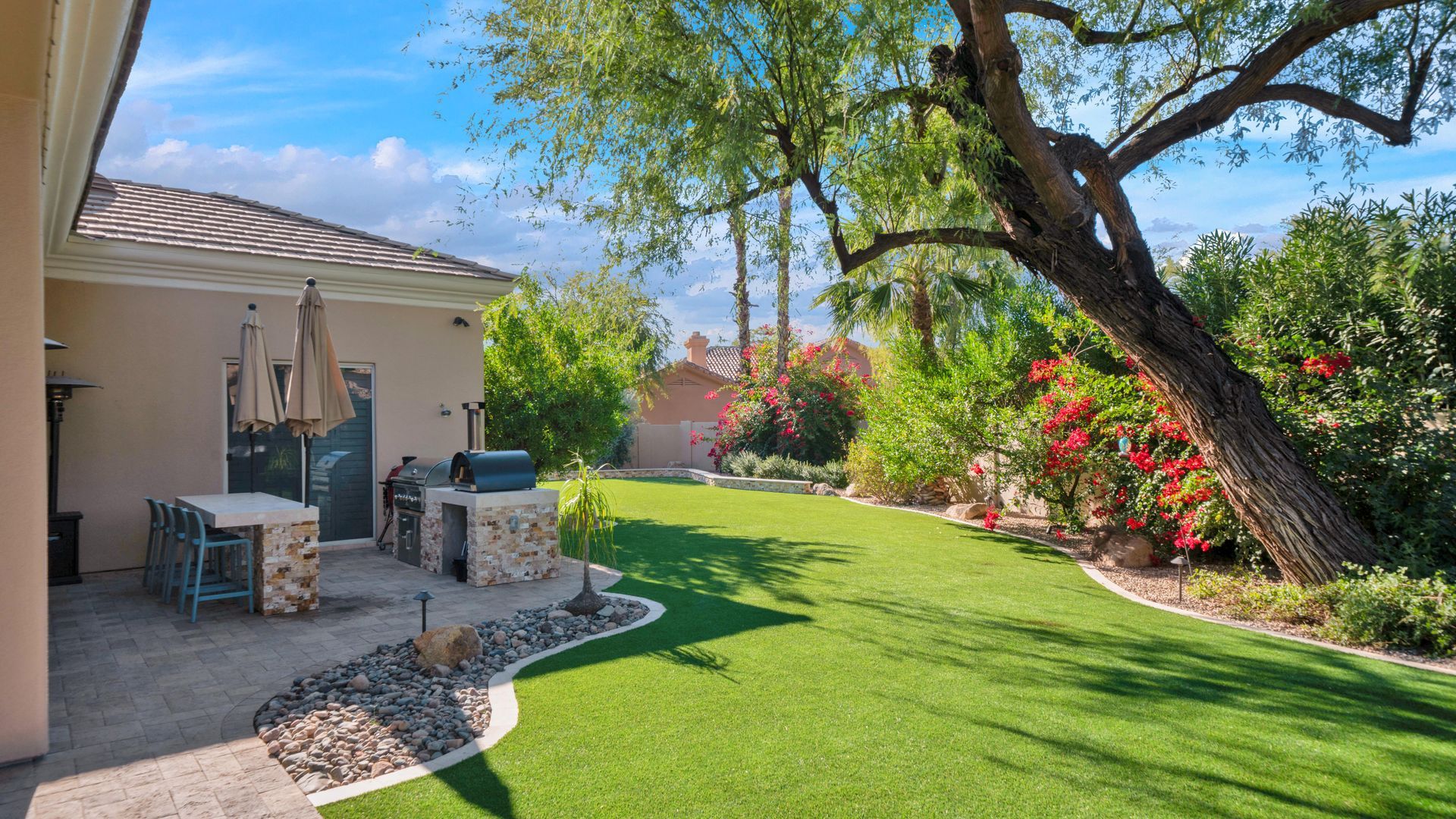 A house with a large lawn and a patio in the backyard.