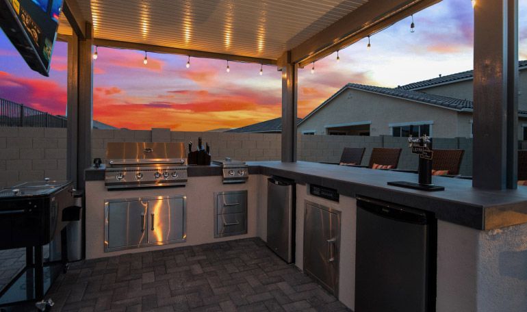 A large outdoor kitchen with a sunset in the background.