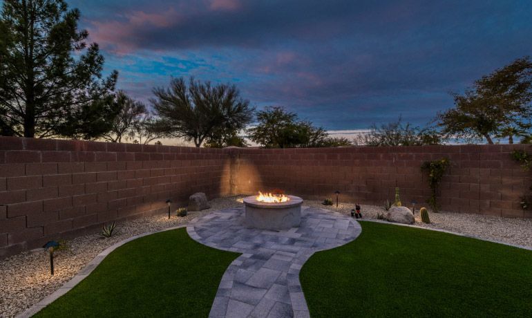 There is a fire pit in the middle of the backyard.