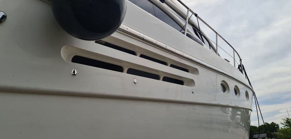 A close up of the side of a boat with a lot of vents on it.