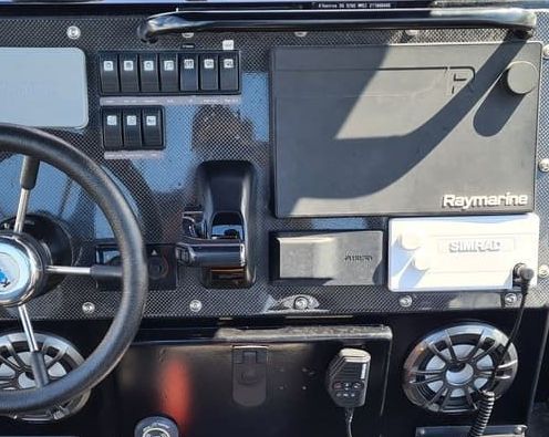 A raymarine dashboard with a steering wheel and speakers