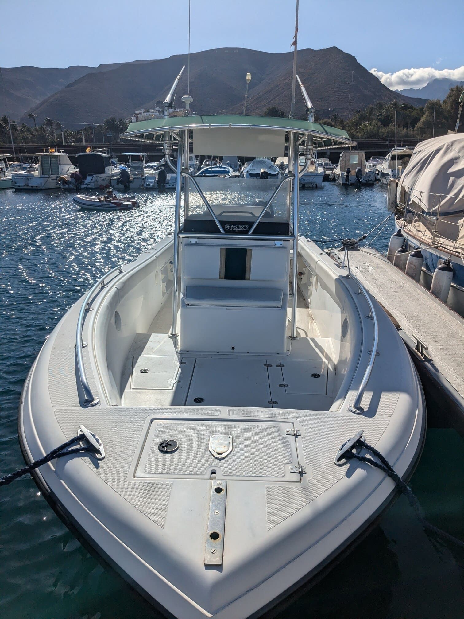 A white boat is docked in a harbor