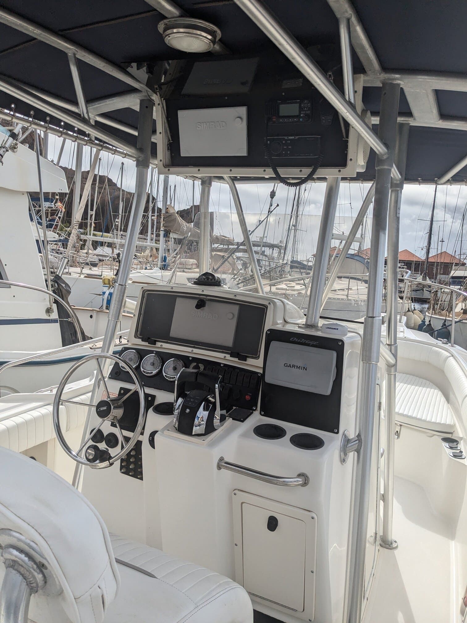The inside of a boat with a steering wheel and controls.