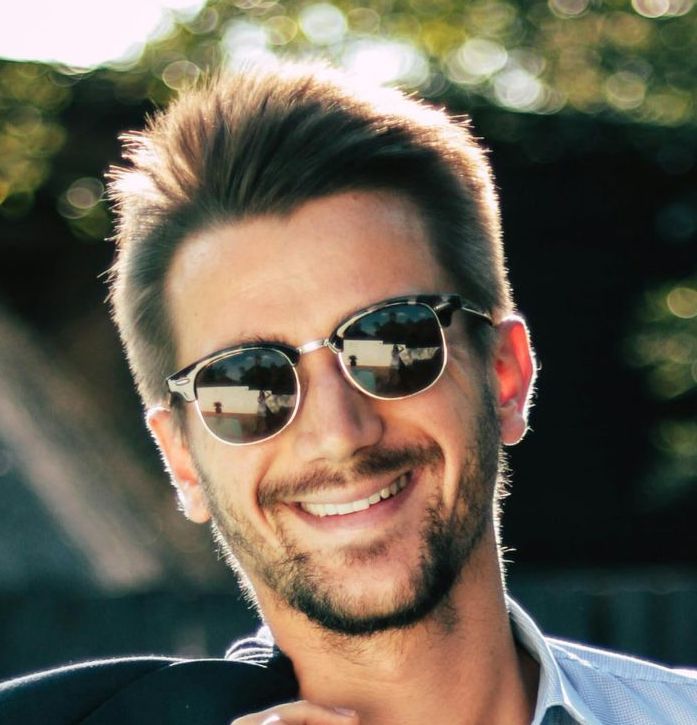 A man wearing sunglasses is smiling