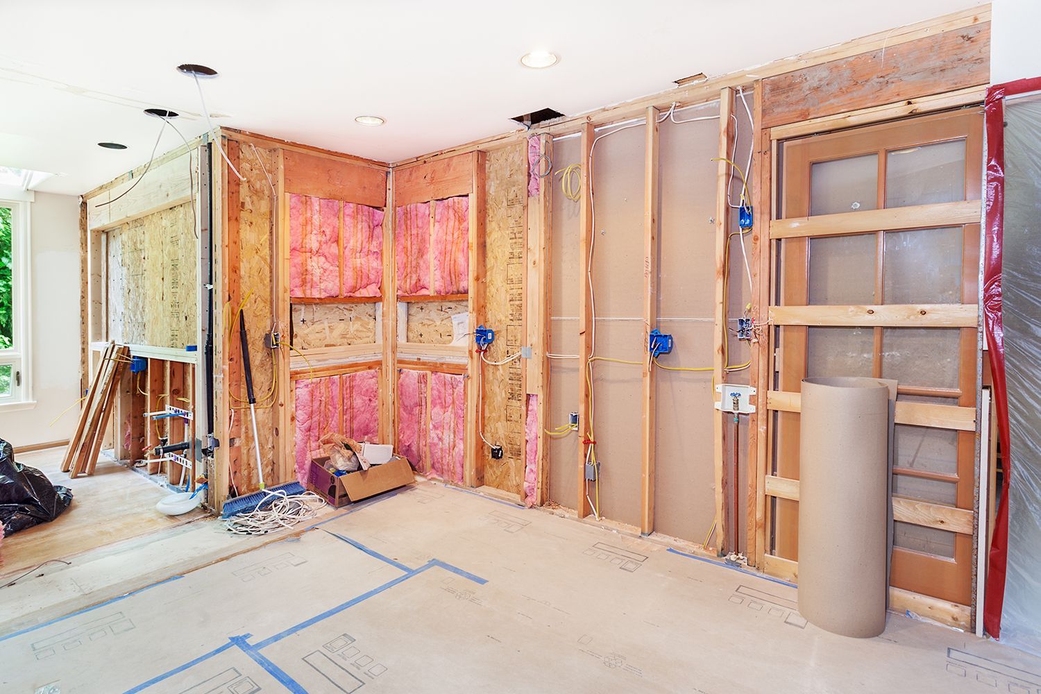A kitchen in the process of being remodeled, showing the insulation layer of one of its walls.