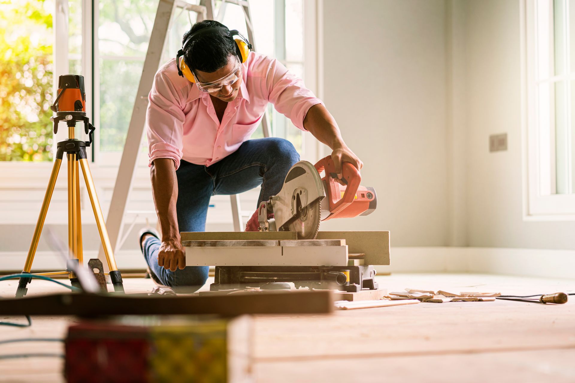 Home improvement contractor cutting wood with a circular saw during an interior renovation project