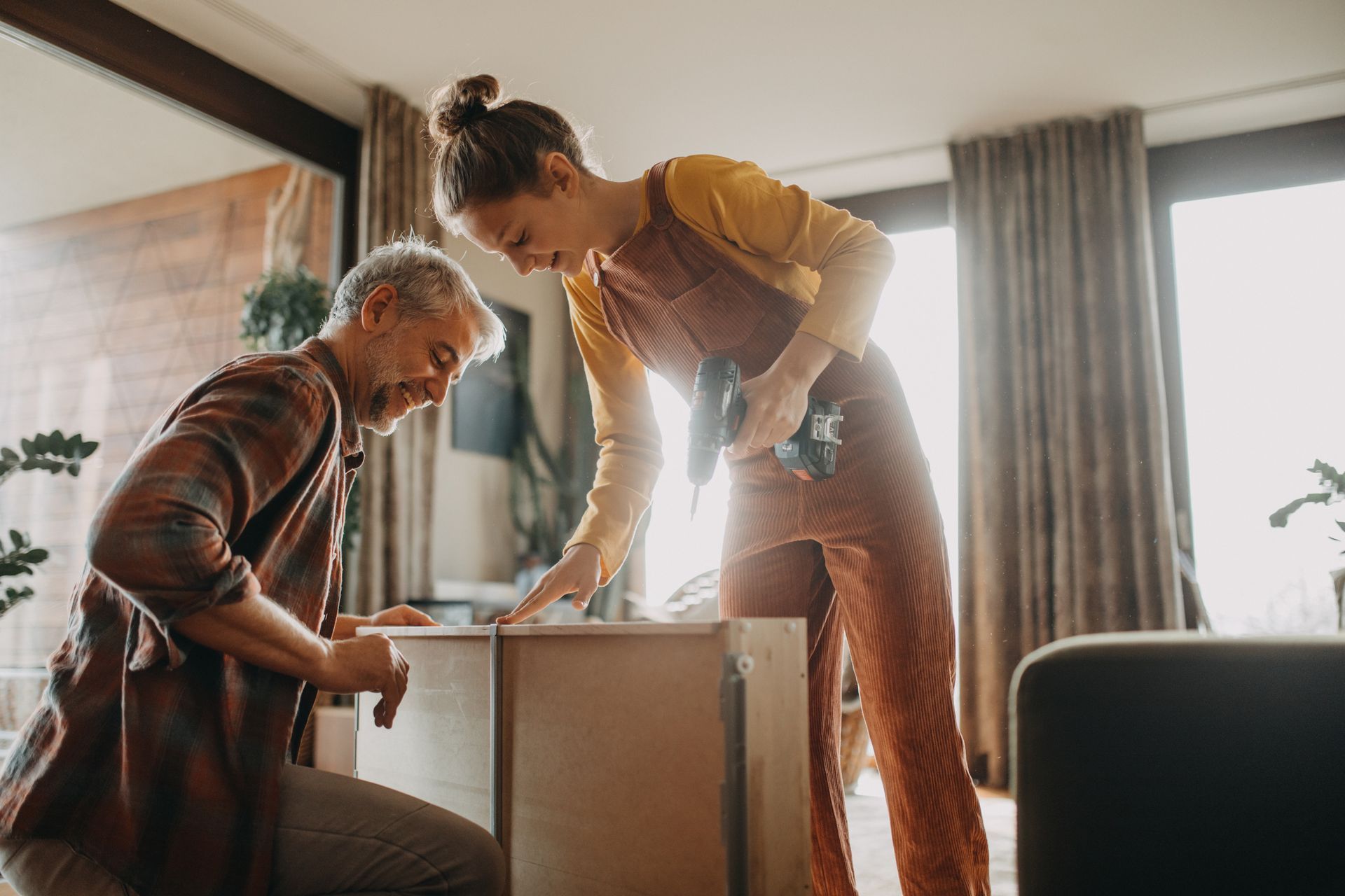Couple assembling furniture in living room during a home improvement project.