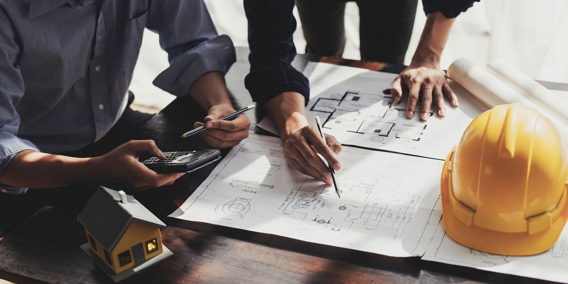 Two men are reviewing some plans and blueprints.