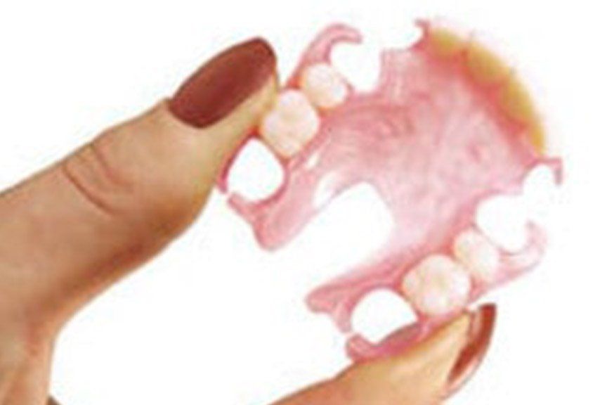 Woman Holding Denture — Dental Services In Sarina, QLD