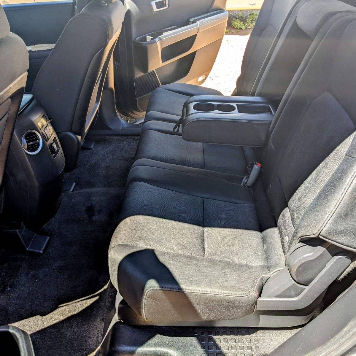 The back seat of a car has a arm rest