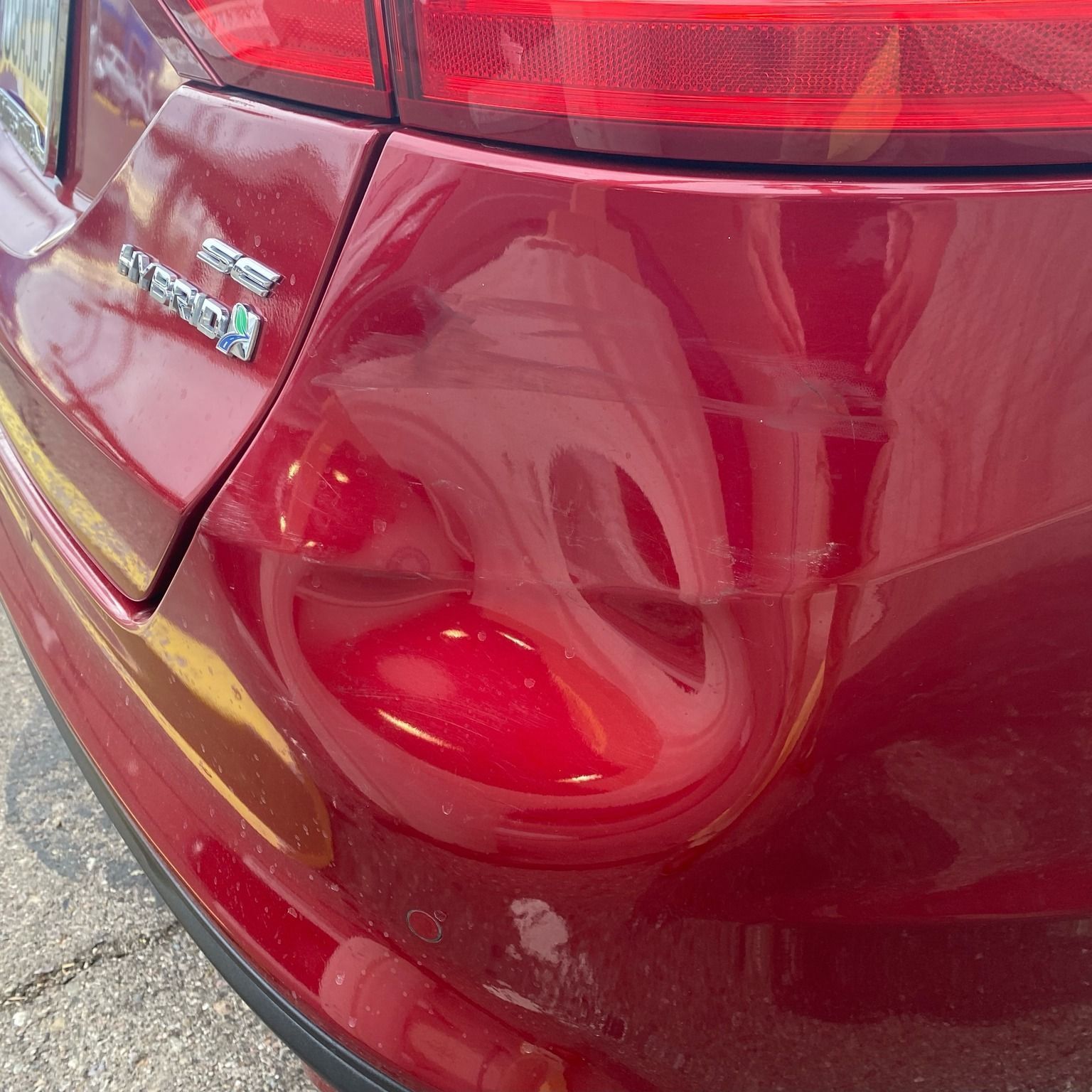 A red car with the word hybrid on the back