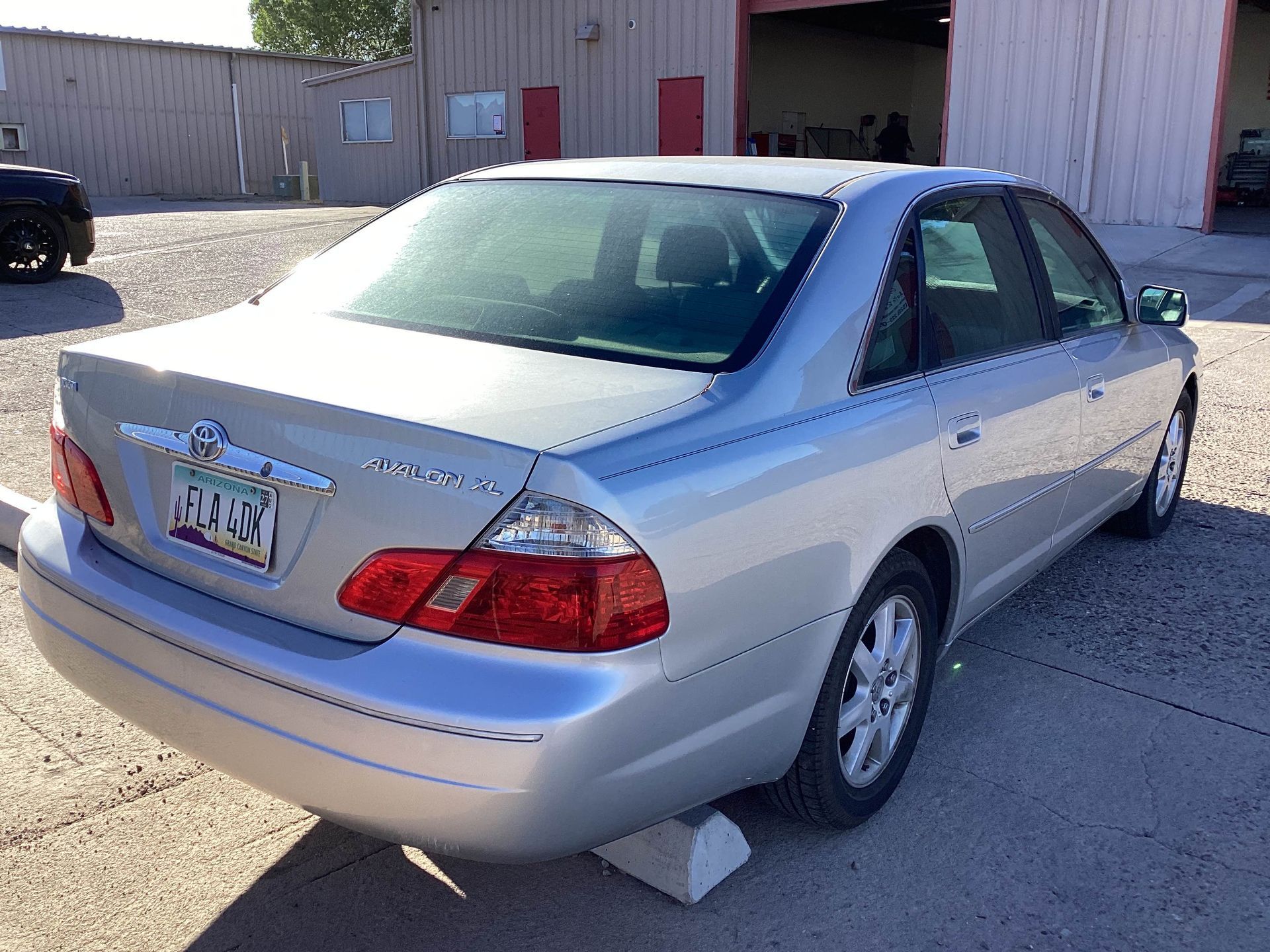 Silver Toyota Avalon sedan parked outside a building.