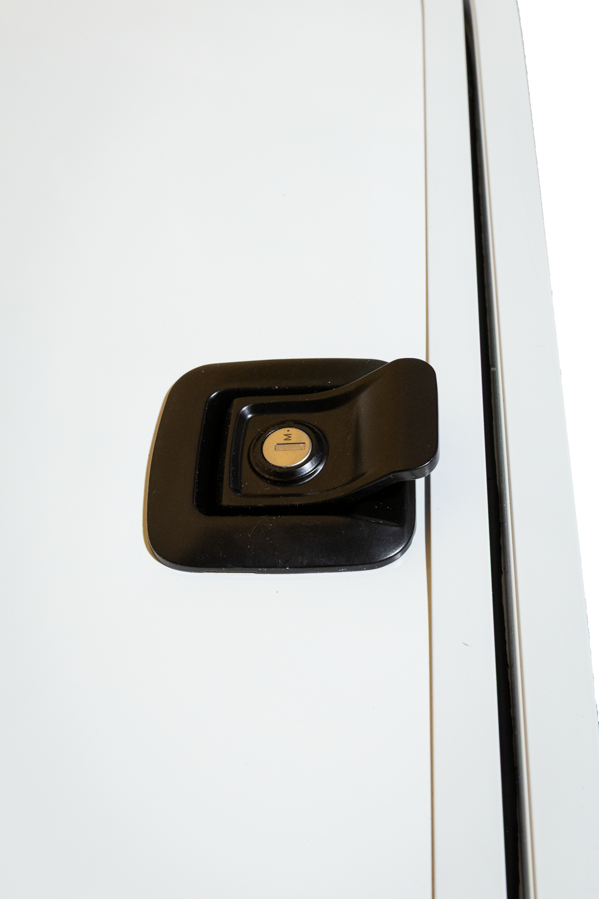 Black car door handle on a white vehicle door, viewed close up.