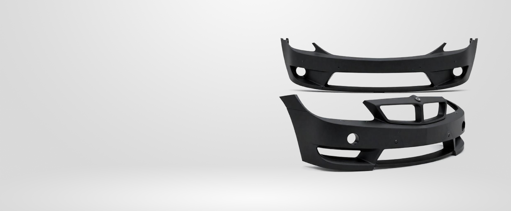 Two black car bumpers against a white background.