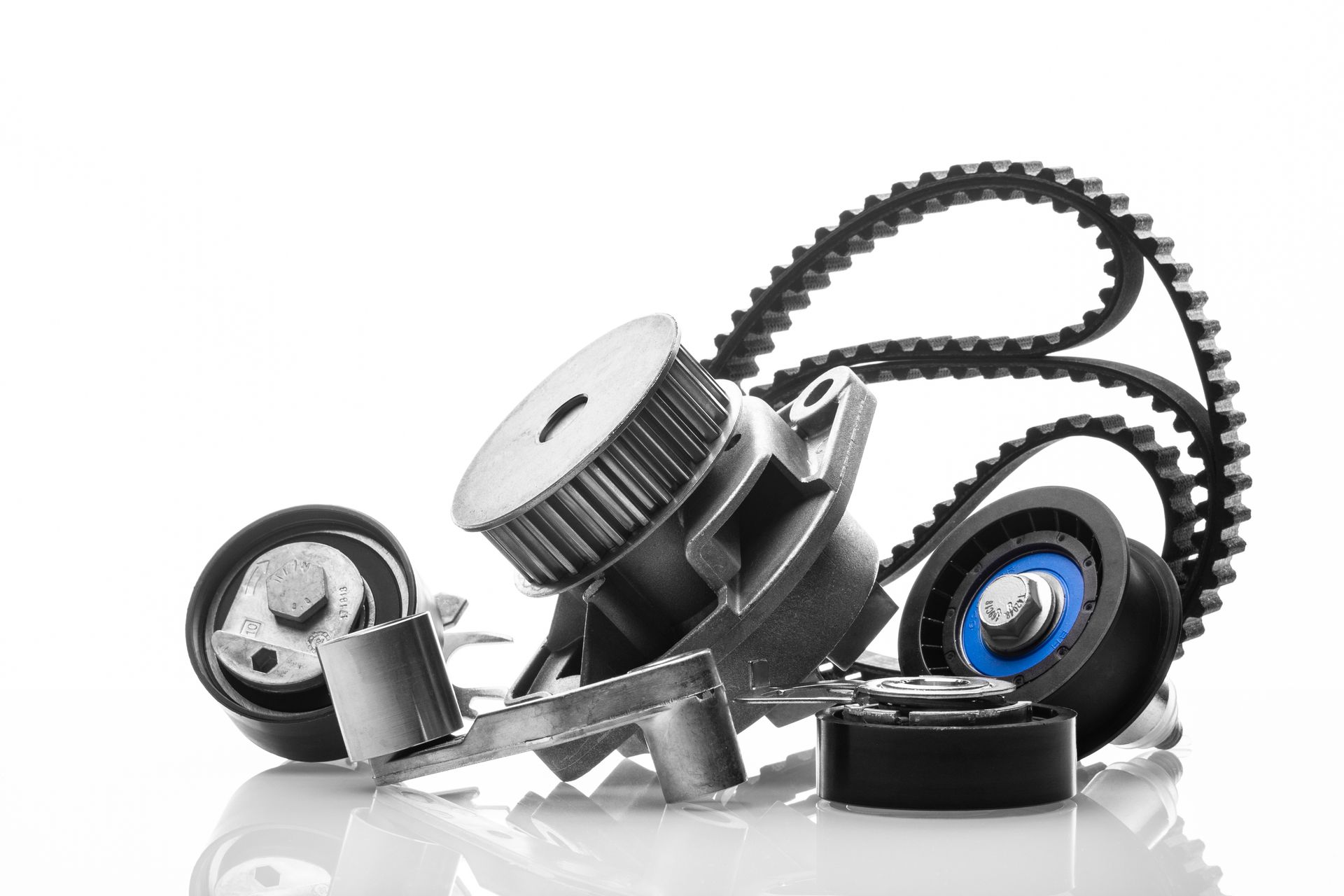 Car engine parts, including a water pump, belts, and pulleys, arranged against a white background.
