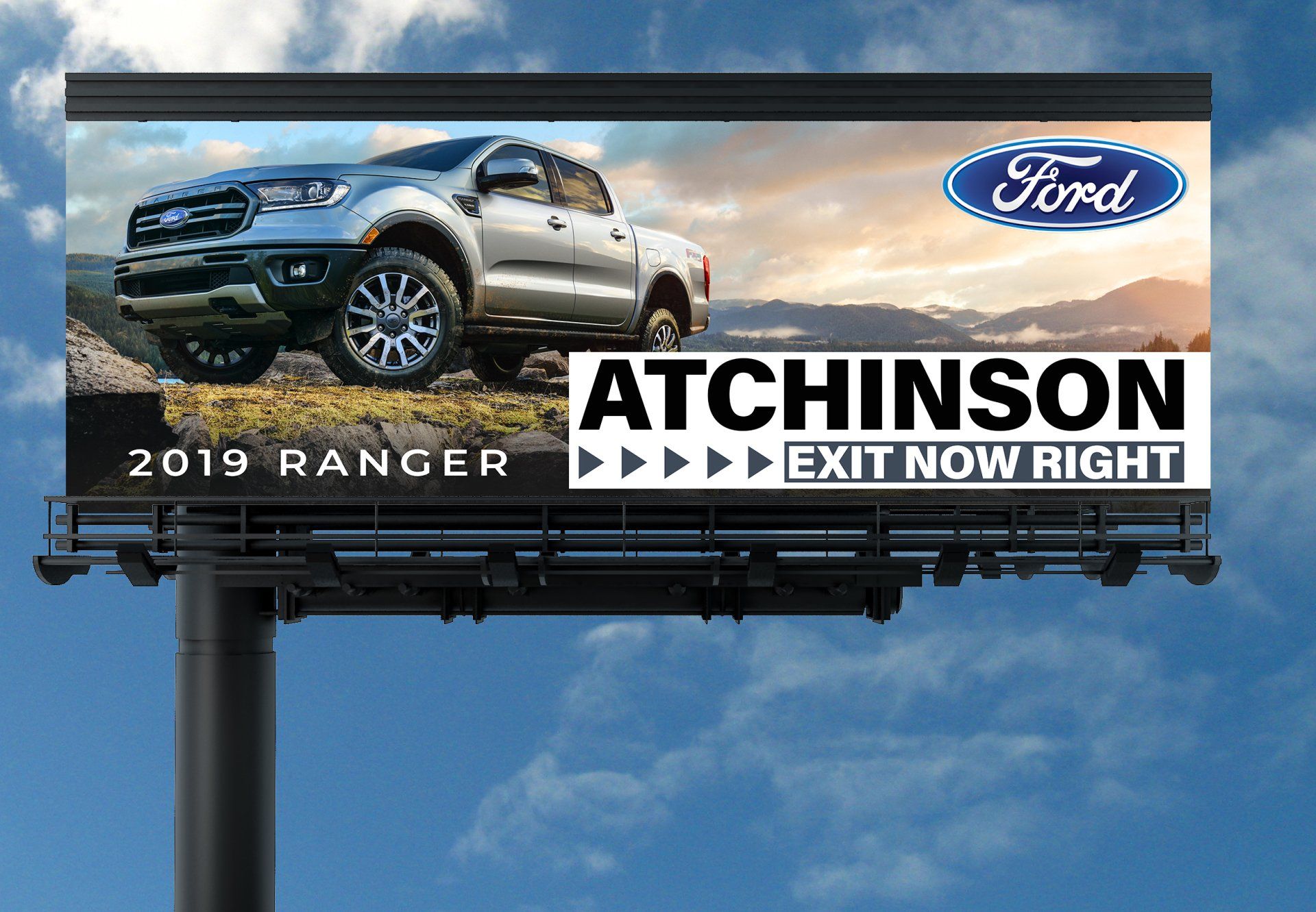 A billboard for a ford ranger truck is against a blue sky.